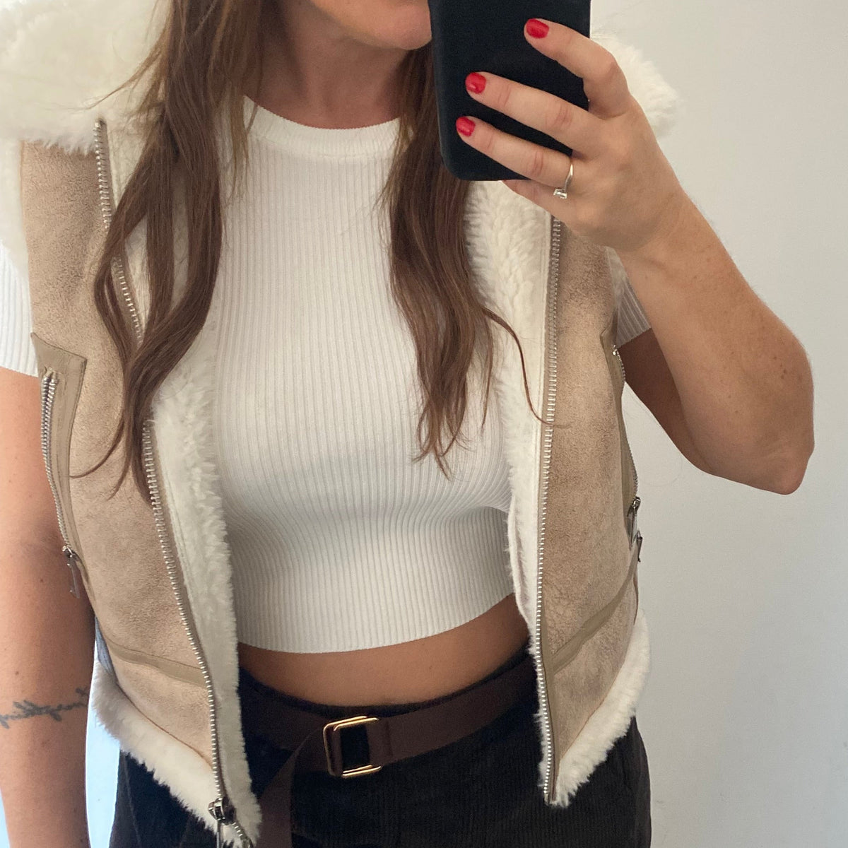 Gilet shearling suède beige porté ouvert sur un crop top blanc