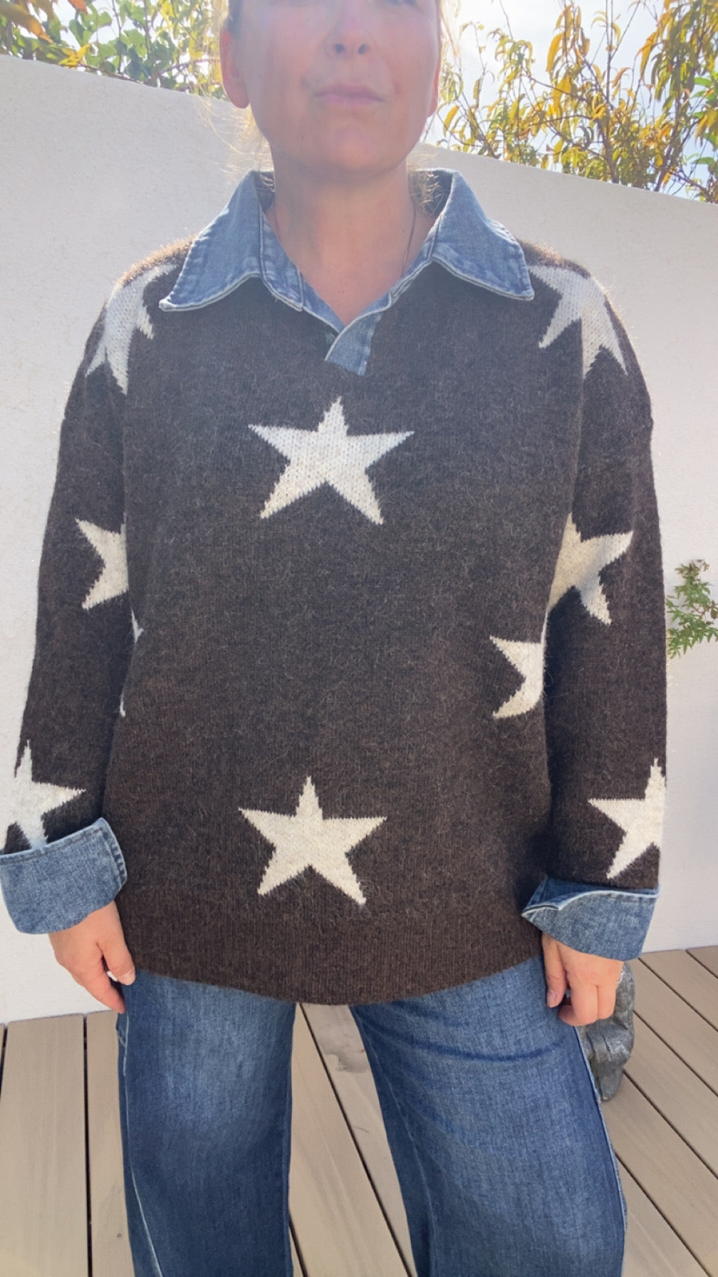 Pull oversize motif étoiles anthracite et blanc porté avec une chemise en jean